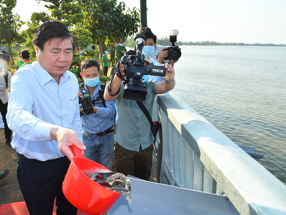 Ông Nguyễn Thành Phong - Chủ tịch UBND TPHCM thả cá trong buổi phát động. Ảnh: Việt Dũng/SGGP